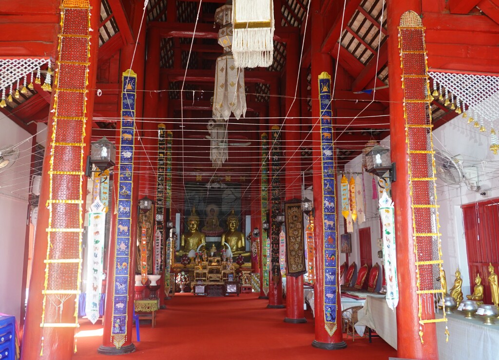 Red columns and carpet inside viharn, Wat Muen Toom, Chiang Mai, Thailand